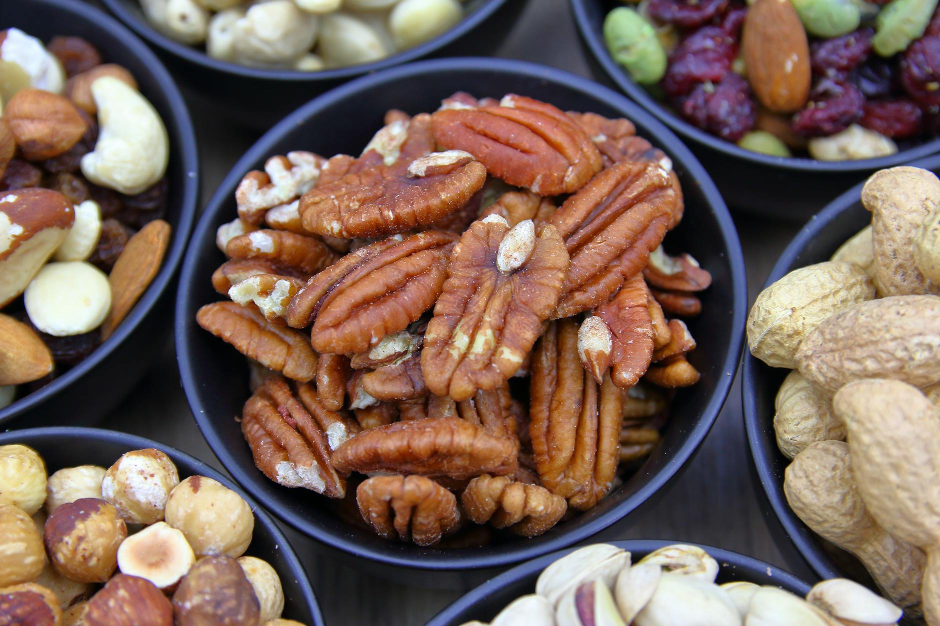 Walnuts and pecans in a wooden bowl, top dietary sources of gamma-tocopherol per USDA FoodData Central